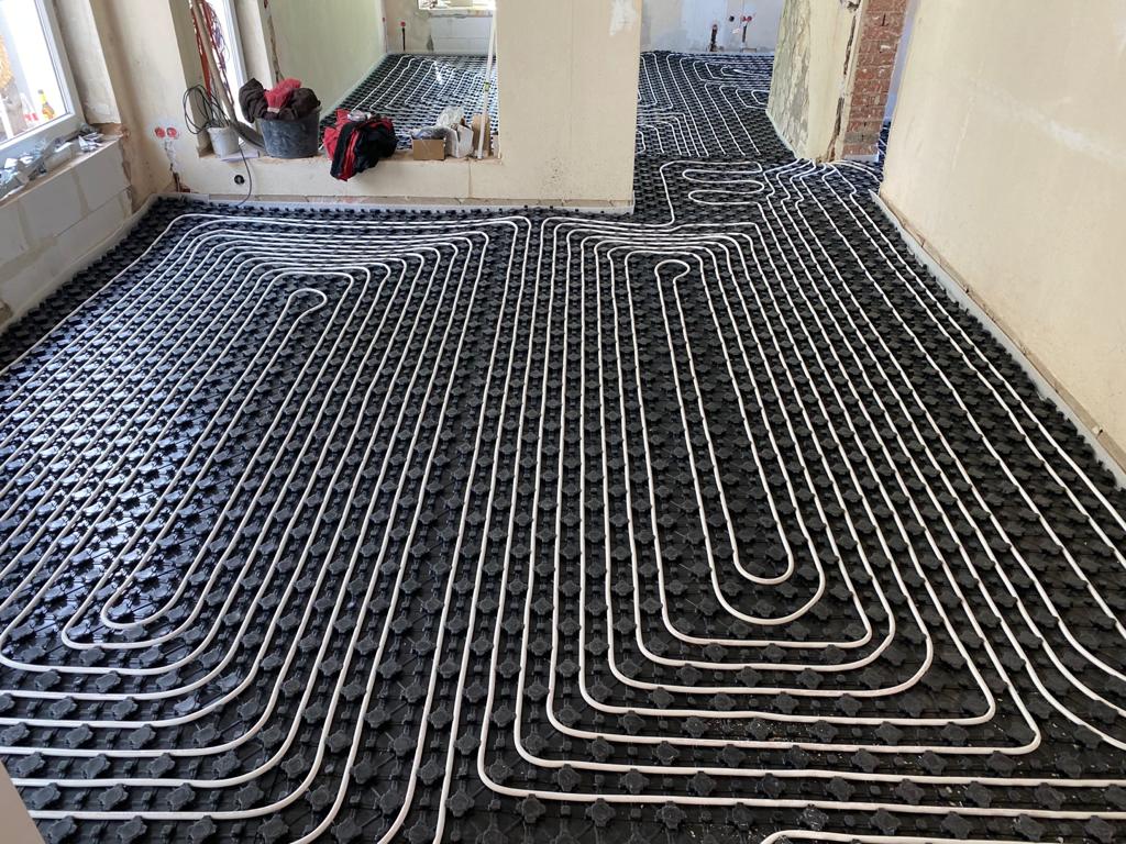 1fe0247c-0b61-43e3-a2eb-1b1fdb1a3d20 Installation einer großflächigen Fußbodenheizung mit verlegten Heizrohren für effiziente Wärmeverteilung und hohen Wohnkomfort.