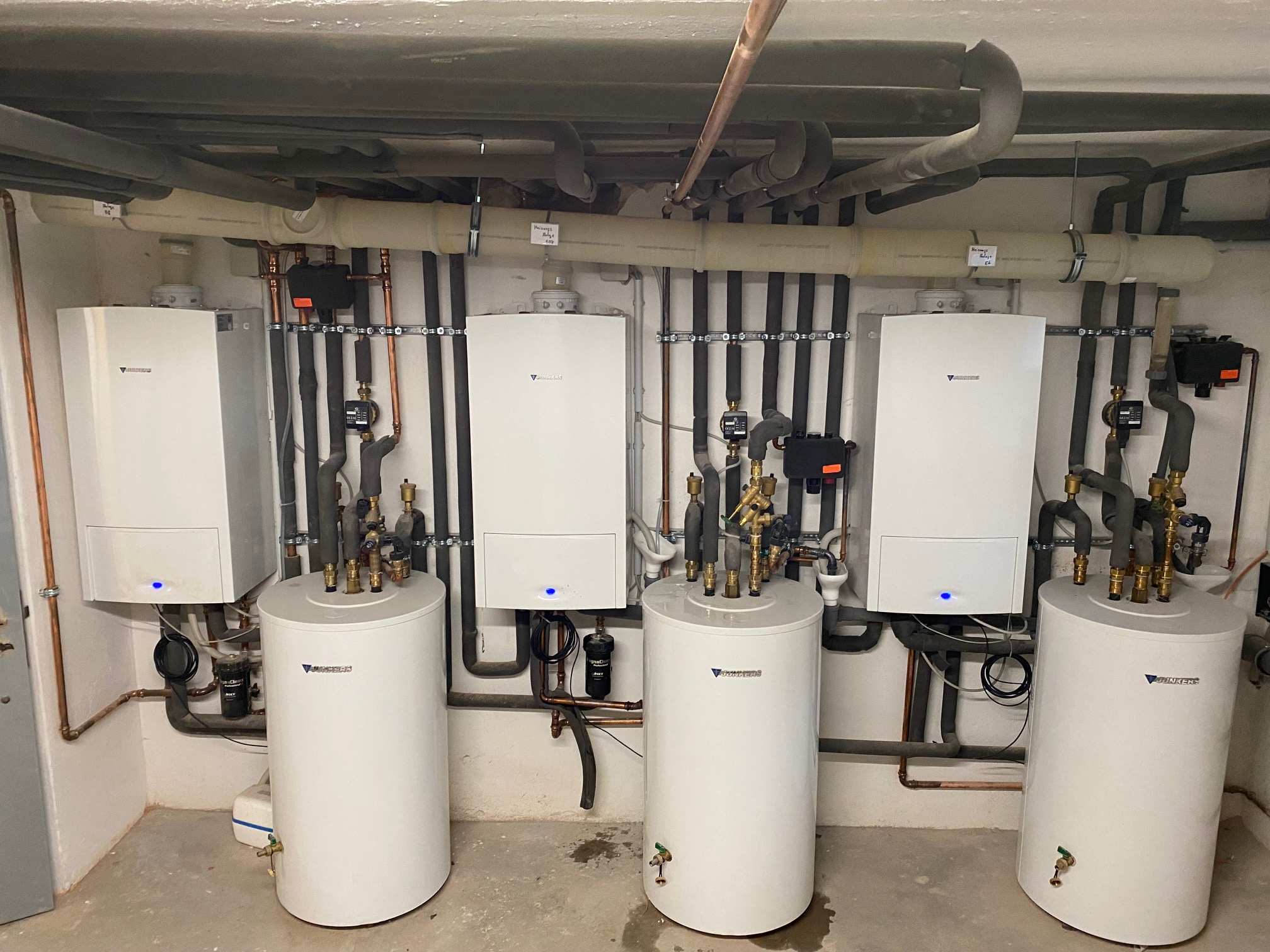Bad Heizung Sanitär Referenzen heizungsanlage Moderner Heizraum mit mehreren Heizkesseln, Warmwasserspeichern und sauber verlegten Leitungen – professionelle Heizungsinstallation durch Haustechnik BHS.