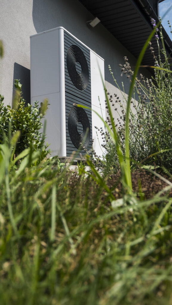External heat pump unit against the wall of the house. Modern technologies for energy saving